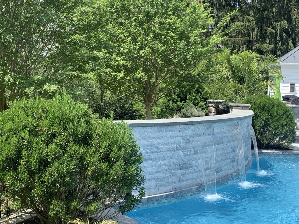 Curved Stone Water Wall Bringing Texture and Tranquility to the Pool Zone